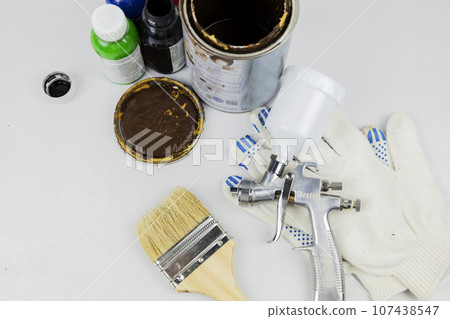 Instructions and a paint spray gun at work at the workplace in the workshop. 107438547
