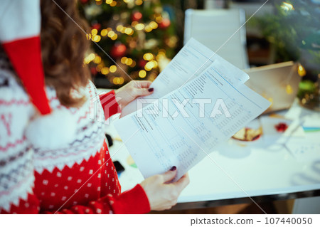 Business owner woman in green office with Christmas tree working 107440050