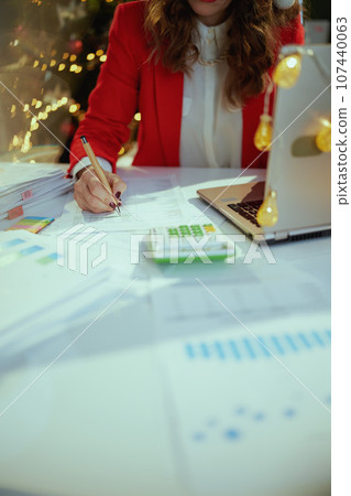 Business owner woman in green office with Christmas tree working 107440063