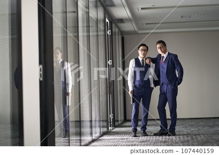 portrait of two asian corporate executives standing in office looking at camera 107440159