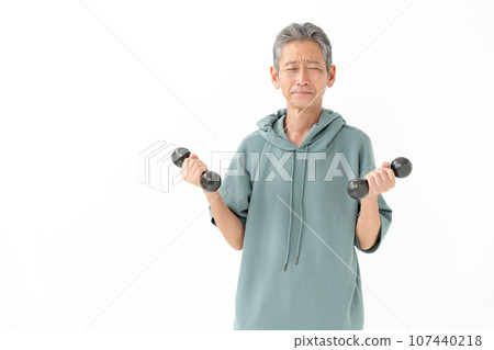 Senior man holding dumbbells with a sad expression 107440218