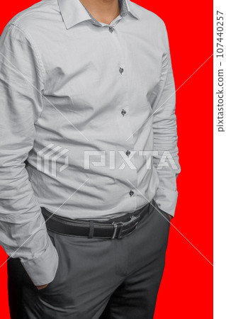 Men's business style clothing fashion white shirt on red isolated background pants grey posing hands pocket 107440257