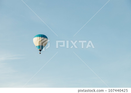 Hot air balloon with tourists against a blue sky. Space for text Hot air balloon with tourists against a blue sky. Space for text 107440425