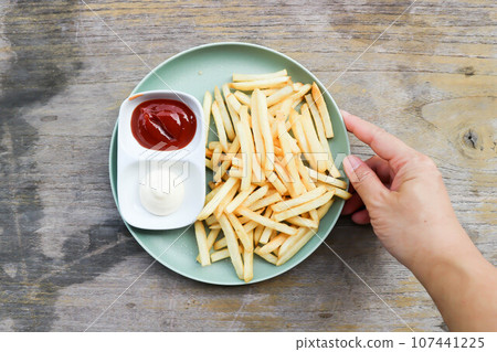 French fries or fried potato , fries with mayonnaise and tomato sauce 107441225