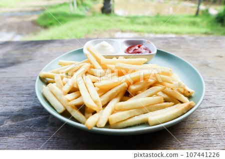 French fries or fried potato , fries with mayonnaise and tomato sauce 107441226