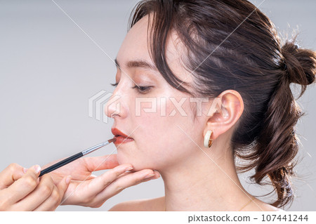 Young lady painting lipstick Young lady painting lipstick 107441244