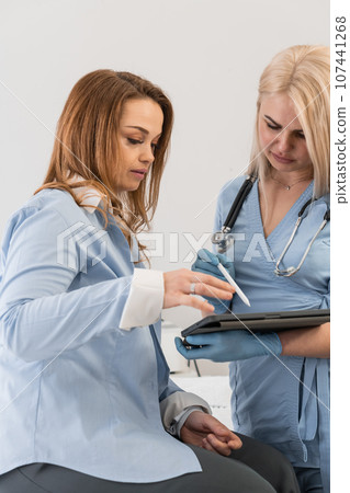 Medical plan: A doctor on a tablet tells a woman about a treatment plan and ways to improve her health. Expert help: The doctor highlights the results of tests and examinations, helping to understand Medical plan: A doctor on a tablet tells a woman about a treatment plan and ways to improve her health. Expert help: The doctor highlights the results of tests and examinations, helping to understand 107441268