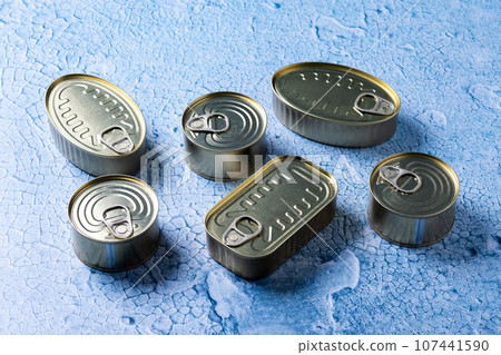 Canned food in metal can on blue background 107441590