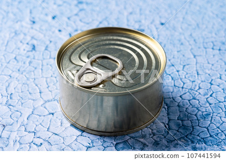 Canned food in metal can on blue background 107441594