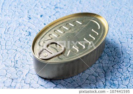 Canned food in metal can on blue background 107441595
