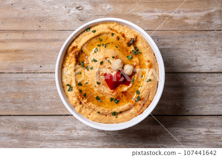 Roasted red pepper hummus on wooden table 107441642
