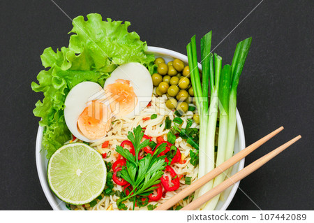 Noodle Dish with Green Onions, Eggs, Green Pea, Red Hot Pepper, Greens and Lime 107442089