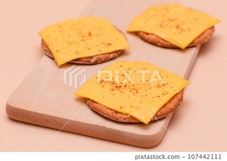 Cracker Sandwiches with Cheese and Paprika on Cutting Board Cracker Sandwiches with Cheese and Paprika on Cutting Board 107442111