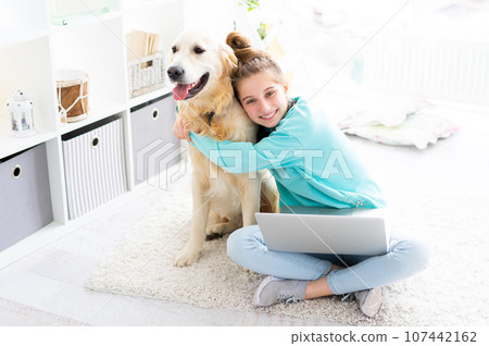girl with pretty dog with laptop in bright room 107442162