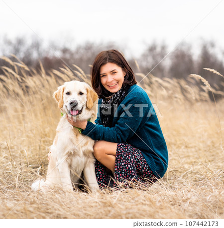 Cheerful woman with devoted dog in early spring nature Cheerful woman with devoted dog in early spring nature 107442173