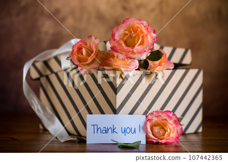 gift box with ribbons and beautiful roses inside. 107442365