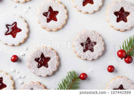 Linzer cookies with sweet jam and fir tree branches on wooden table. Top view Linzer cookies with sweet jam and fir tree branches on wooden table. Top view 107442899