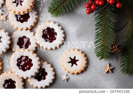 Linzer cookies with sweet jam and fir tree branches on wooden table. Top view 107443190