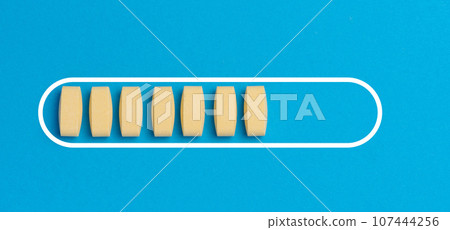 Yellow oval tablets on a blue background, top view 107444256