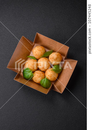 Delicious round balls of mozzarella and parmesan cheese with salt and breaded spices 107445248