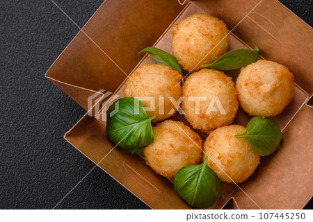 Delicious round balls of mozzarella and parmesan cheese with salt and breaded spices 107445250