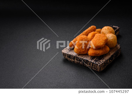 Delicious nuggets, sticks and balls of mozzarella and parmesan cheese with salt and spices 107445297