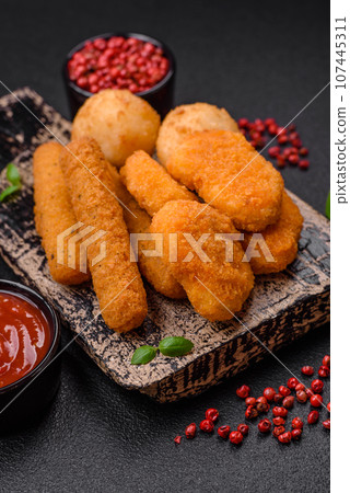 Delicious nuggets, sticks and balls of mozzarella and parmesan cheese with salt and spices 107445311