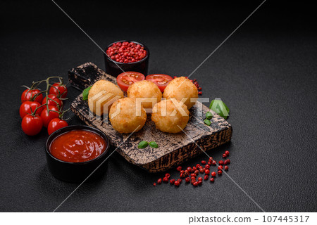 Delicious round balls of mozzarella and parmesan cheese with salt and breaded spices 107445317