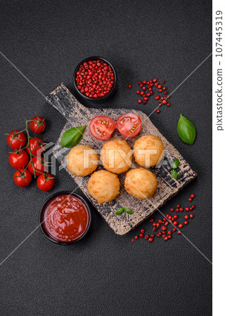 Delicious round balls of mozzarella and parmesan cheese with salt and breaded spices 107445319