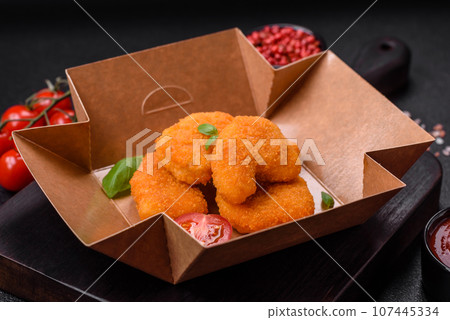 Delicious fresh crispy chicken nuggets on a dark concrete background 107445334