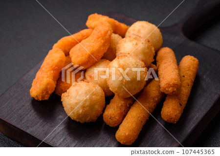 Delicious nuggets, sticks and balls of mozzarella and parmesan cheese with salt and spices 107445365