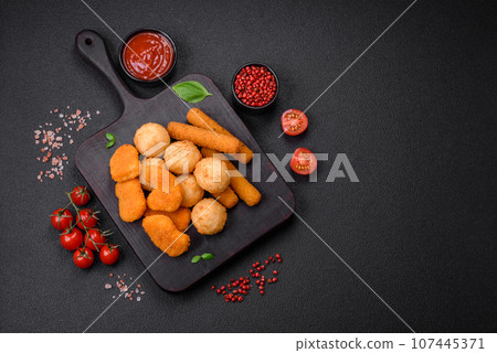 Delicious nuggets, sticks and balls of mozzarella and parmesan cheese with salt and spices Delicious nuggets, sticks and balls of mozzarella and parmesan cheese with salt and spices 107445371