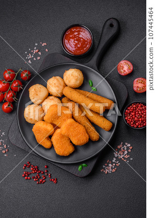 Delicious nuggets, sticks and balls of mozzarella and parmesan cheese with salt and spices Delicious nuggets, sticks and balls of mozzarella and parmesan cheese with salt and spices 107445464