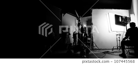 Silhouette images of making of or behind the scenes of video production which produced in the film studio that include all pro light and camera equipment and professional film crew with movie director Silhouette images of making of or behind the scenes of video production which produced in the film studio that include all pro light and camera equipment and professional film crew with movie director 107445568