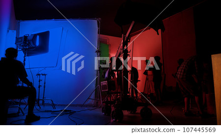 Silhouette images of making of or behind the scenes of video production which produced in the film studio that include all pro light and camera equipment and professional film crew with movie director Silhouette images of making of or behind the scenes of video production which produced in the film studio that include all pro light and camera equipment and professional film crew with movie director 107445569