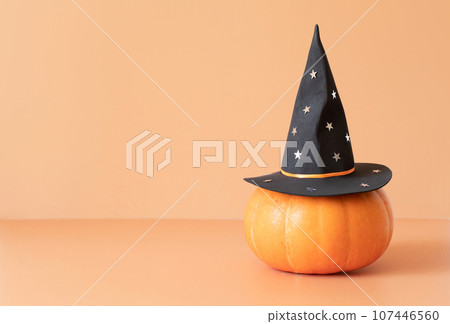 Pumpkin in magic hat on beige background. Halloween pumpkin in a witch hat. Banner. Halloween decorations. Space for text. 107446560