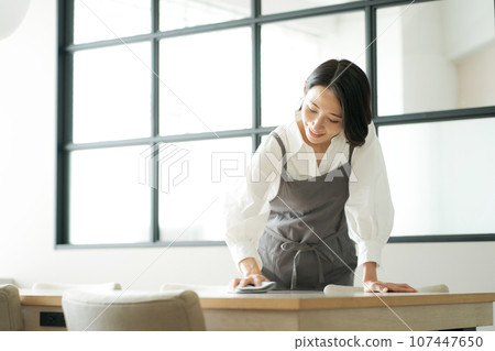 photo of a woman wiping the table photo of a woman wiping the table 107447650