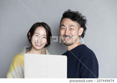 Smiling couple with computer Smiling couple with computer 107449474