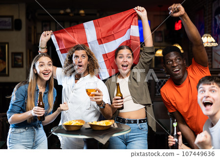 Group of Denmark football team fans spending time in bar Group of Denmark football team fans spending time in bar 107449636