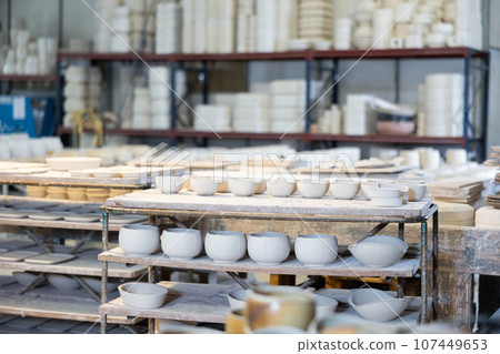 Abundance of crafted ceramic bowls in pottery workshop 107449653
