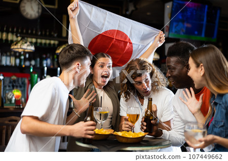 Men and women supporting Japan sports team in pub Men and women supporting Japan sports team in pub 107449662