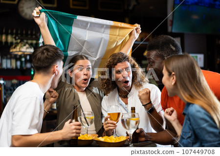 Group of Ireland football team fans spending time in bar 107449708