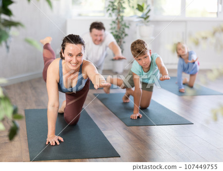 Family with two children doing yoga in studio Family with two children doing yoga in studio 107449755
