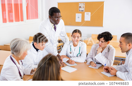 Professor explaining subject to group of medical students Professor explaining subject to group of medical students 107449883