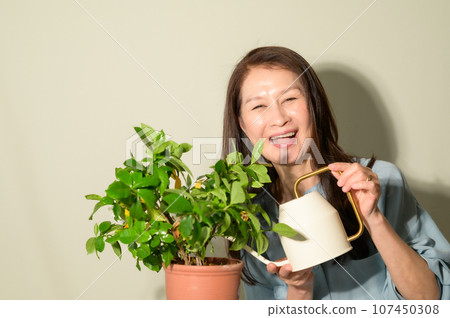 Senior woman watering plants Senior woman watering plants 107450308