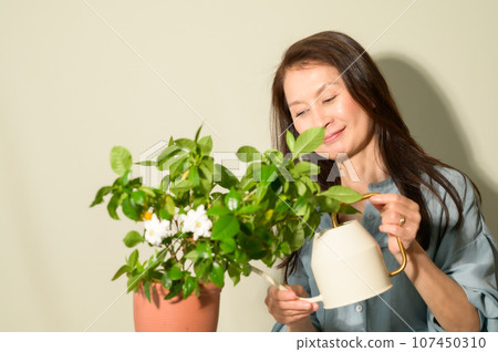 Senior woman watering plants Senior woman watering plants 107450310