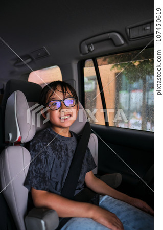 A boy in a car gets wet. 107450619