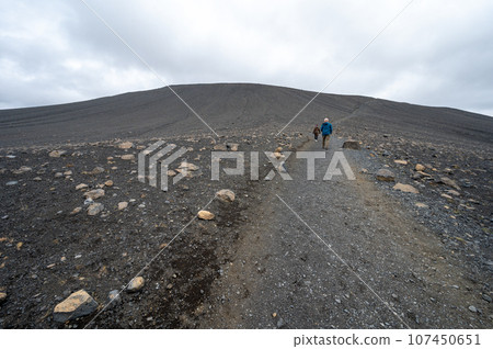 Hikers ascend trail to rim of Hverfjall crater east of Myvatn, Iceland. 107450651