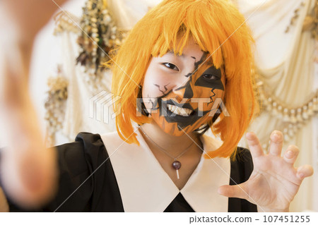 Child doing face painting Pumpkin makeup 107451255