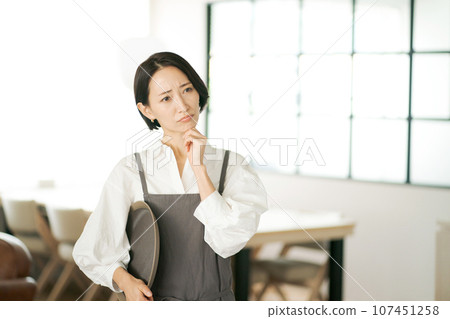 A clerk thinking at a cafe A clerk thinking at a cafe 107451258